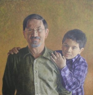 Portrait of a man with glasses and a young boy with his arm around the man’s shoulder.